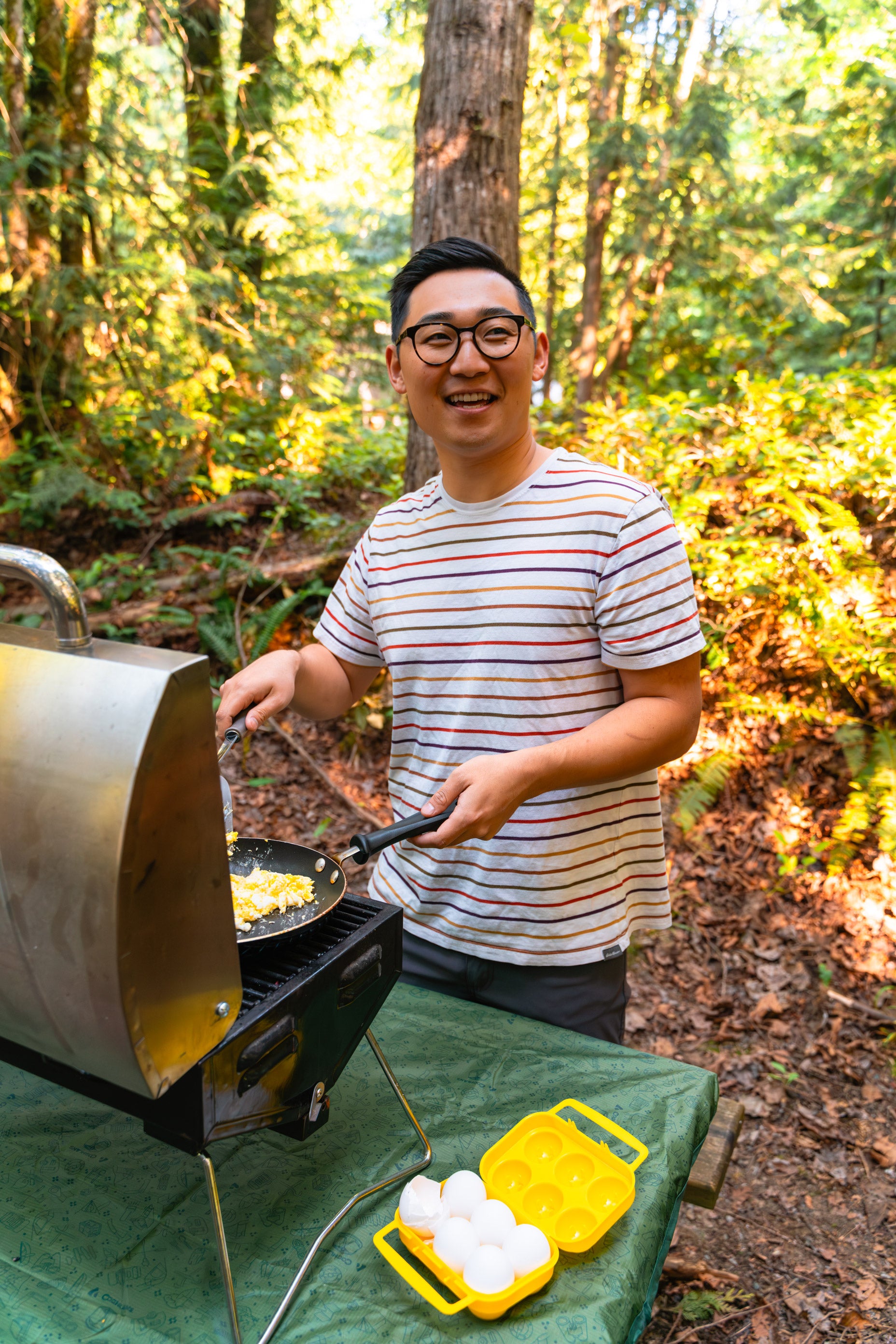 Male cooking eggs at a campground.