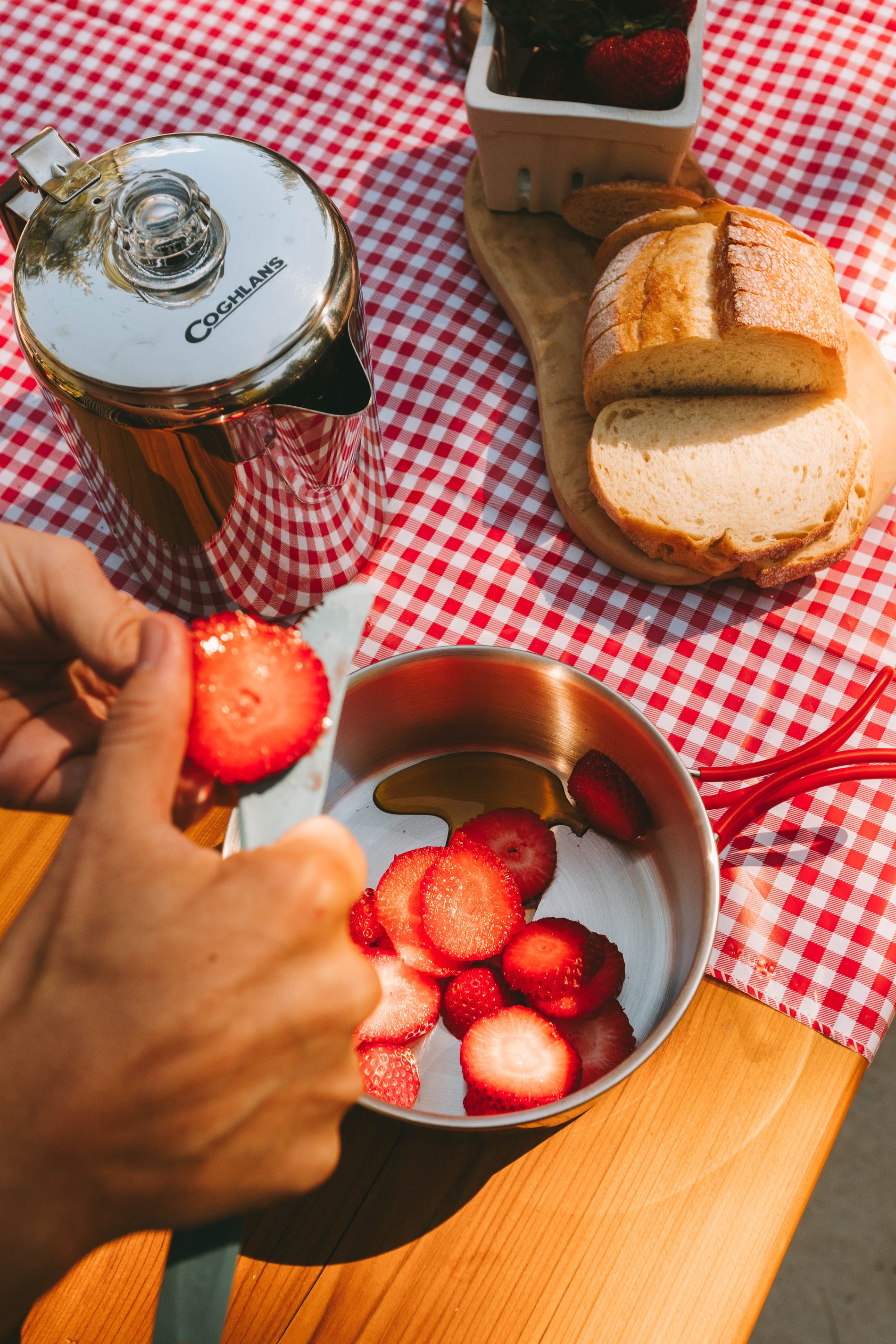 slicing strawberries into a pot