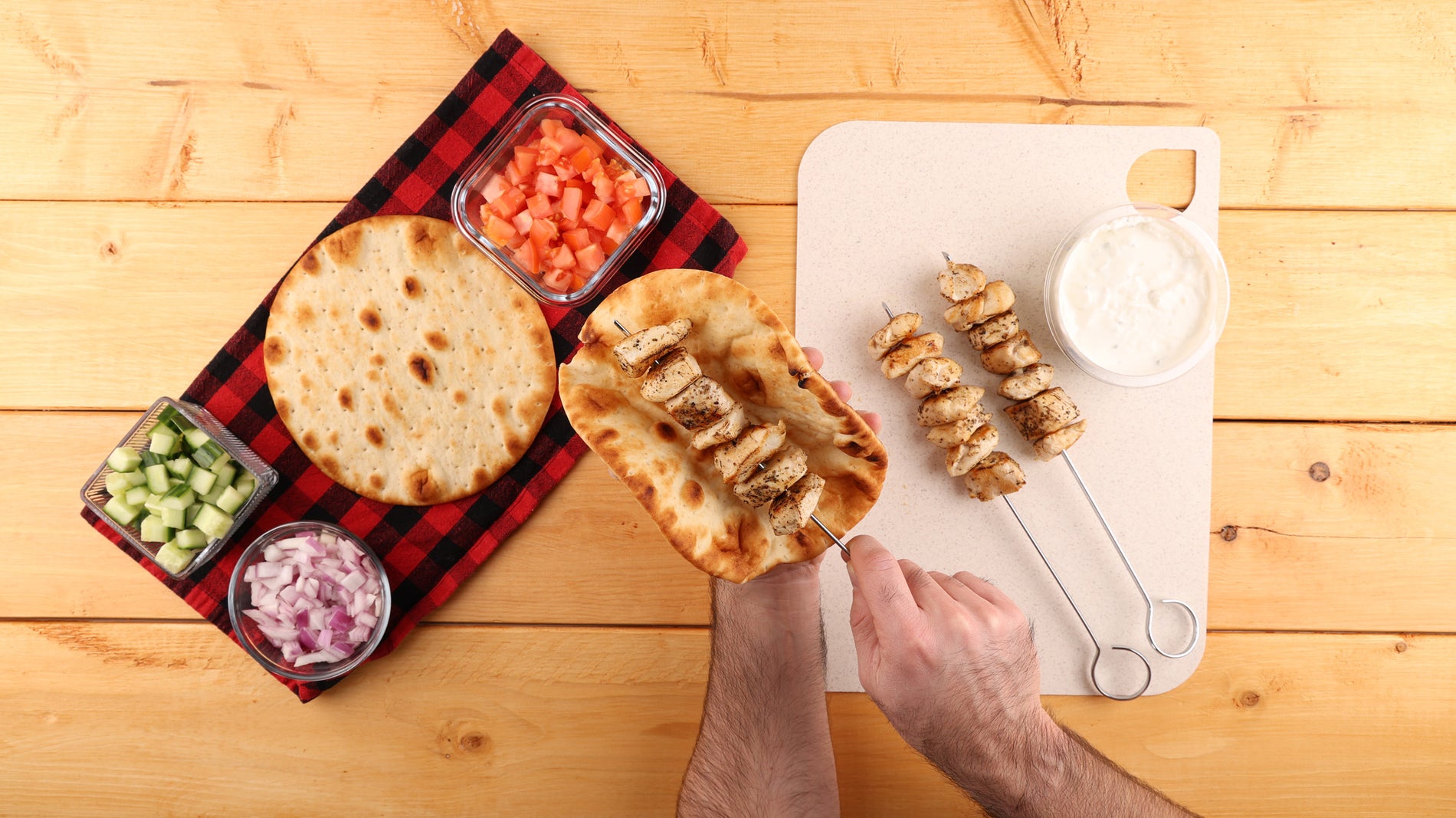 Adding chicken to naan bread from the skewer