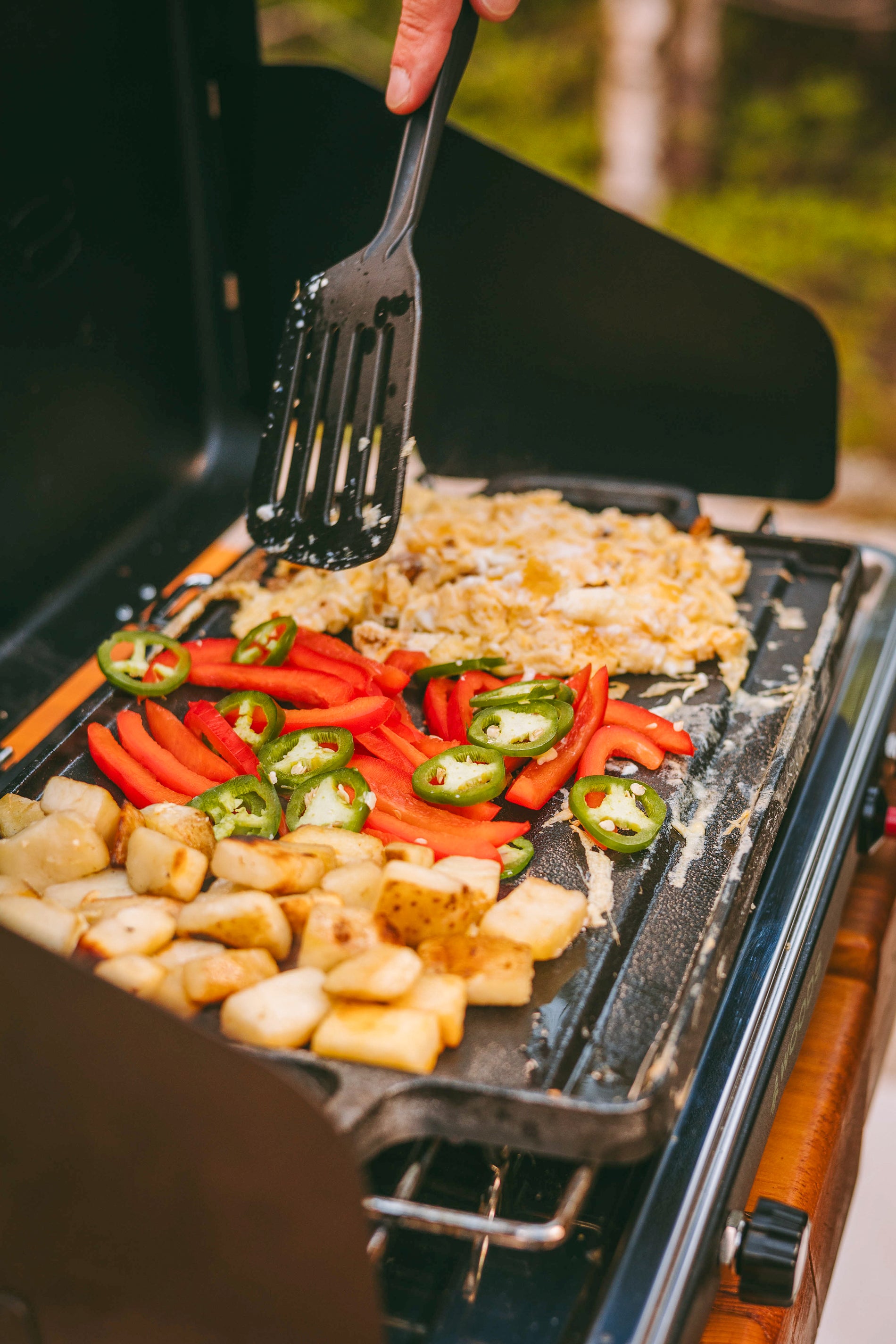 Cooking hash browns, peppers, and scrambled eggs on a Coghlan's cast iron griddle on a camp stove