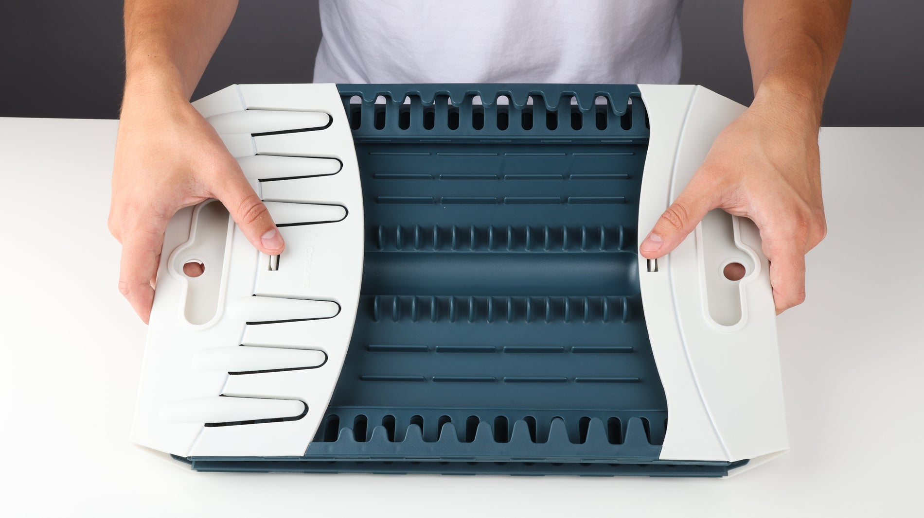 Hands holding the left and right clip locks of the Coghlan's Snapfold Dish Rack