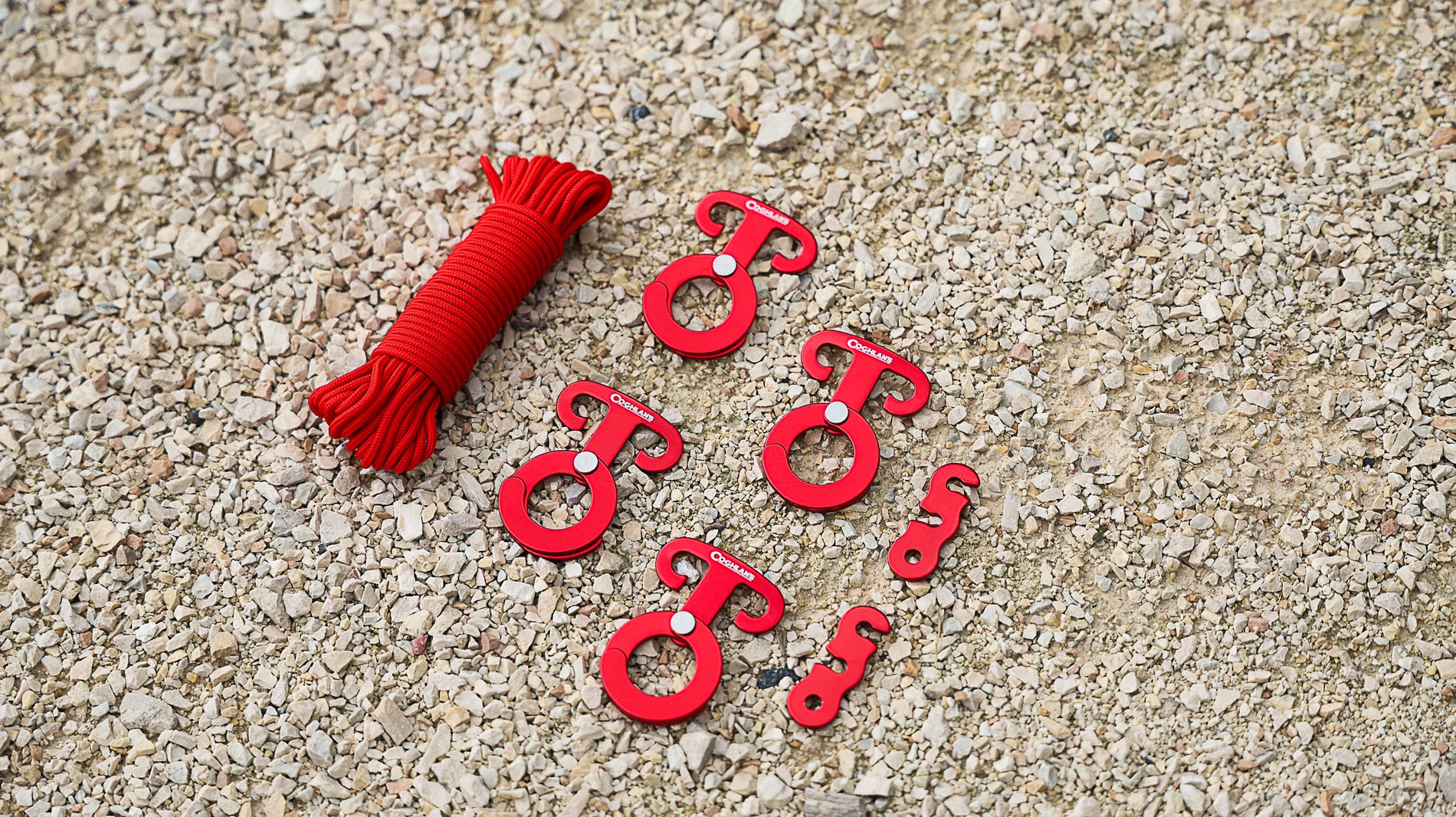 Coghlan's Anchor Clip Set on the Ground - Includes 25-foot Cord, 4 Anchor Clips, 2 Tensioners. All in Red Color.