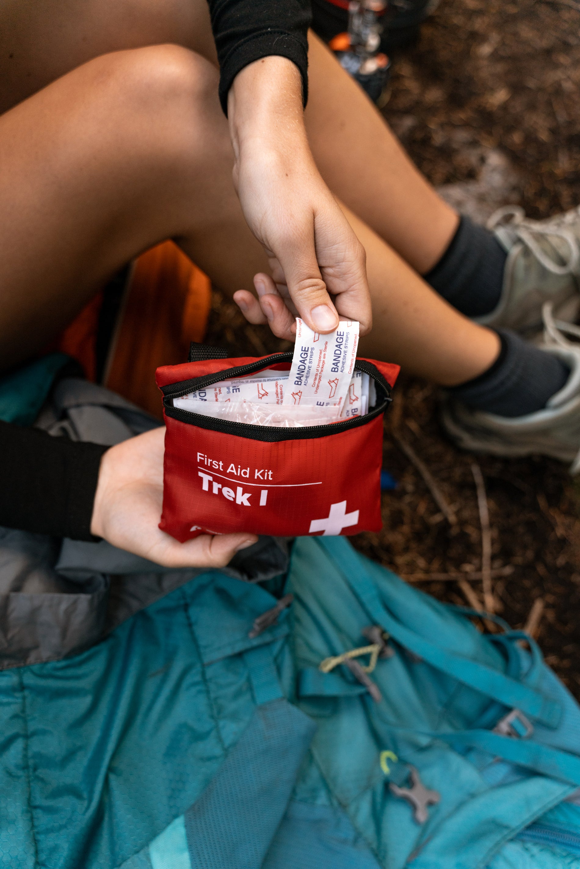 Hiker pulling bandages out of a first aid kit.