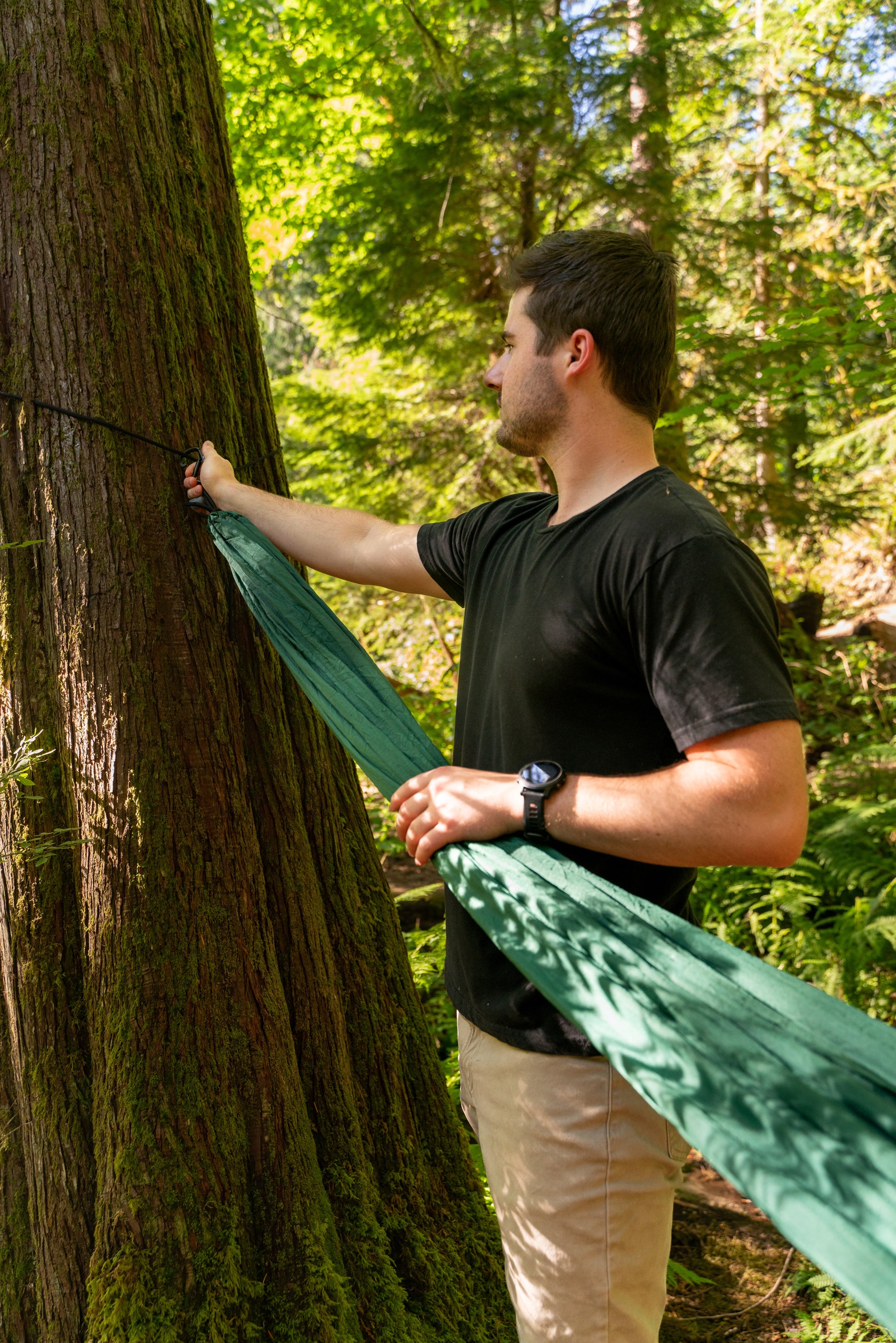 man hanging hammock on tree