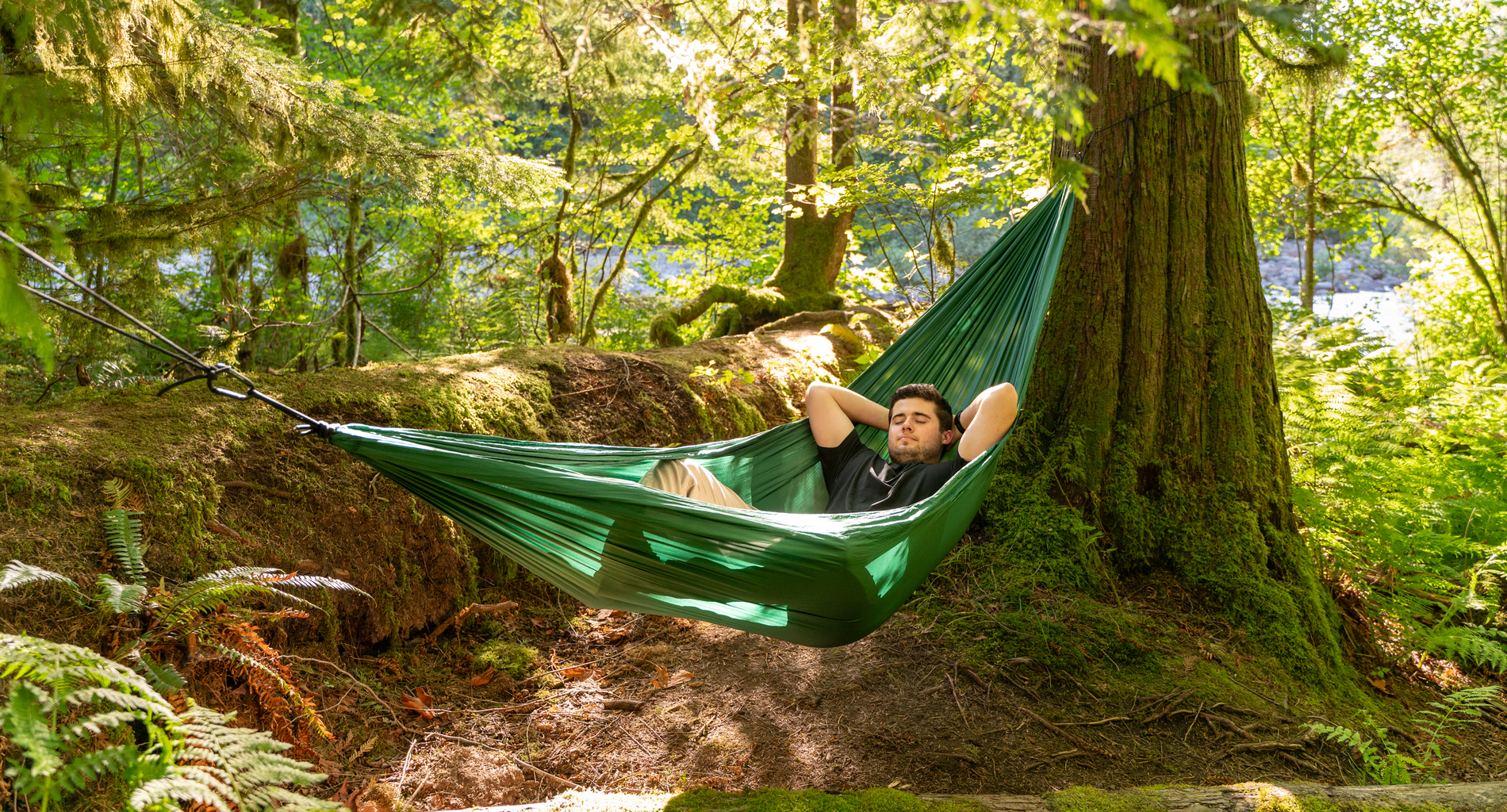 man sleeping in hammock in forest