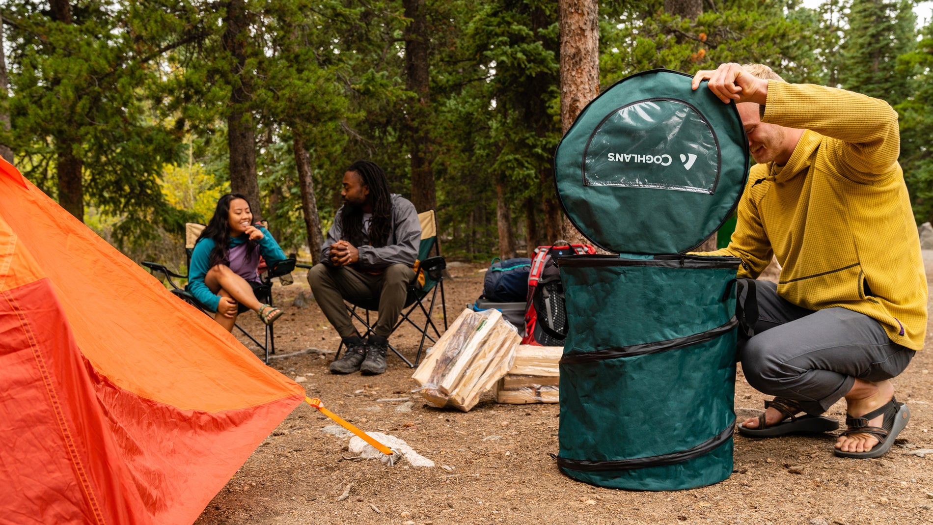 campsite with man opening pop-up trash can
